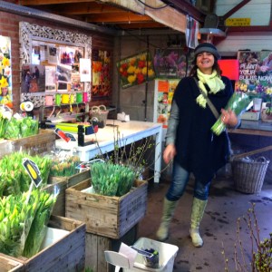 vrouw met bos bloemen in bloemenwinkeltje