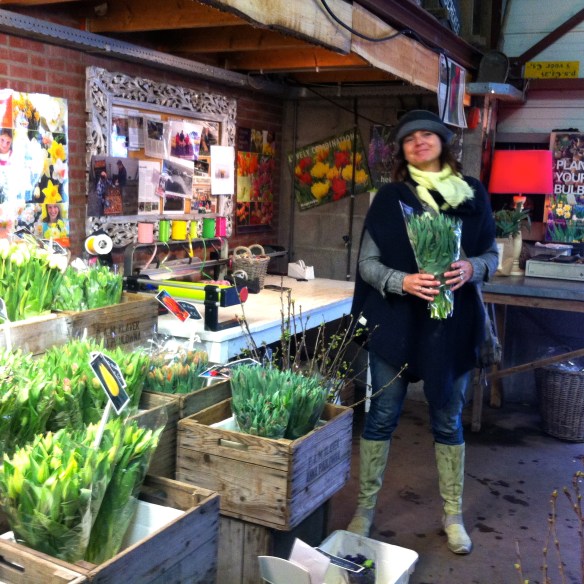 vrouw met bos bloemen in bloemenwinkeltje