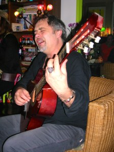 Als enige kan hij uit de voeten met de Blokker Gitaar , mannen op feestje,vrouw op feestje, feestje, heksenfeest, verkleedde mensen op feest, party, muziek maken op party, proost, tante, gezellig kletsen op verjaardag