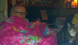 slapende man met roze deken, gebloemd, , kat, kat kijkt naar slapende man